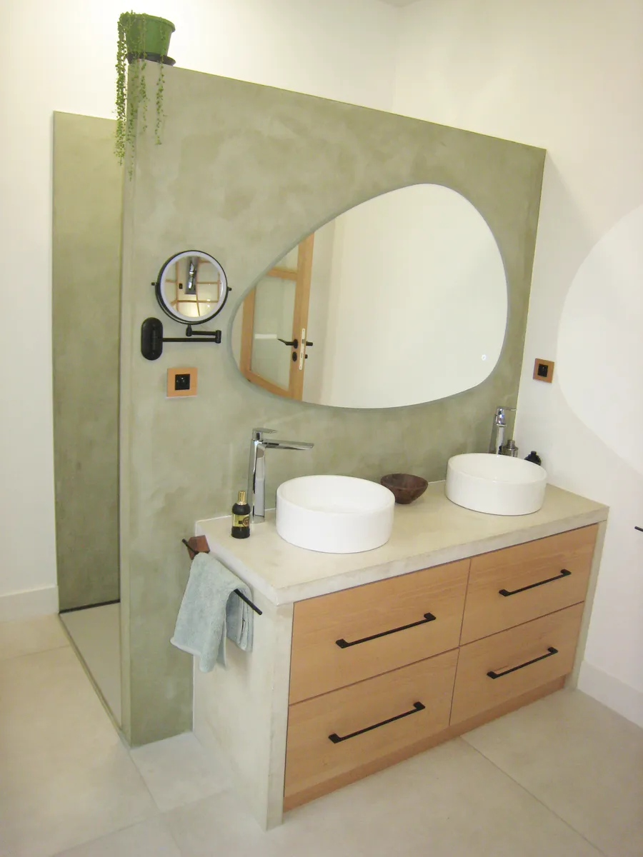 Salle de bain contemporaine avec cloison en béton ciré appliqué par l’Atelier J. GUERIN